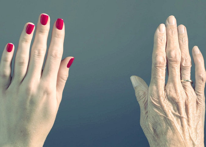 A young woman’s hand contrasts with an old woman’s hand