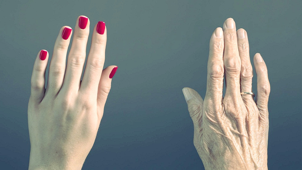 A young woman’s hand contrasts with an old woman’s hand